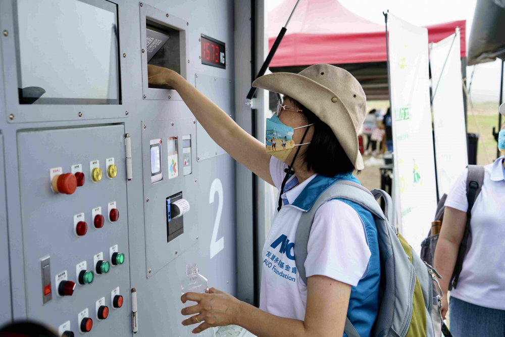 志工們將拾起的寶特瓶投入「好歸塑專車」，讓廢棄塑料空瓶可以直接粉碎、縮小體積，未來將可再製成購物袋、寶特衣、悠遊卡等生活用品